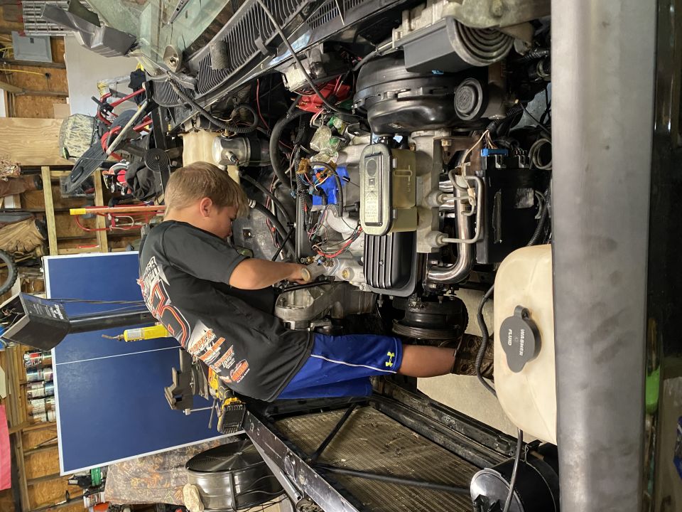Engine compartment with a young person working on the engine