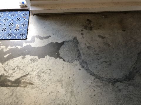 1995 Mercury Grand Marquis - Concrete floor shows wet patches and a blue doormat near a wall.