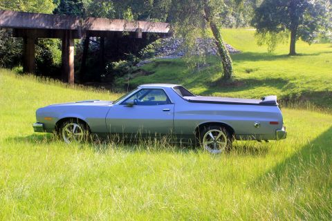 1976 Ford Ranchero - A light blue 1972 Ford Ranchero pickup truck sits in a grassy field next to a concrete structure.