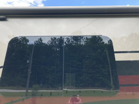 2015 Ford F-550 - Reflection in RV window shows trees and sky. Supermotors.net logo is present.