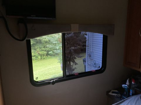 2015 Ford F-550 - View from inside a vehicle's cabin through a window, looking out at a residential yard and house.