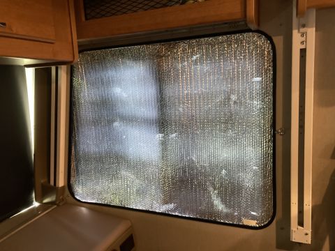 2015 Ford F-550 - Reflective insulation covers the interior window of an RV, obscuring the view outside.
