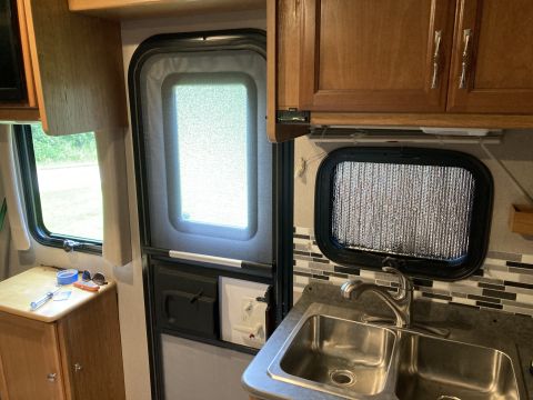 2015 Ford F-550 - Interior view of an RV showing a kitchen area with a sink and cabinets.