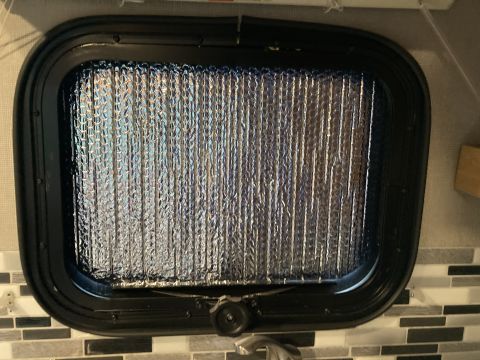2015 Ford F-550 - Interior view of a vehicle window covered with reflective insulation, obscuring the view outside.