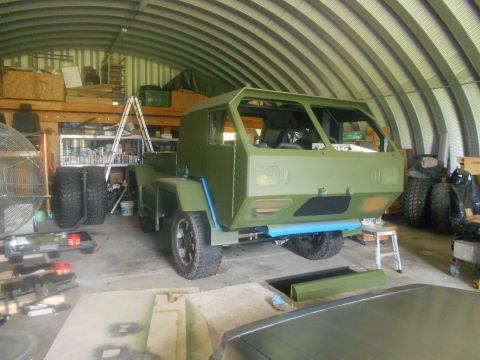 1992 Ford Bronco - A military truck is being worked on inside a Quonset hut garage.