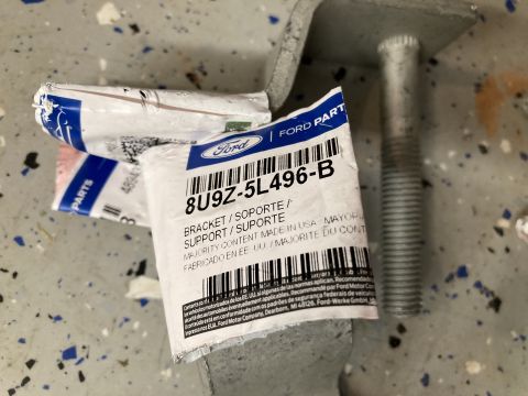 2015 Ford F-550 - Ford part packaging for a bracket and support is shown next to a large bolt.
