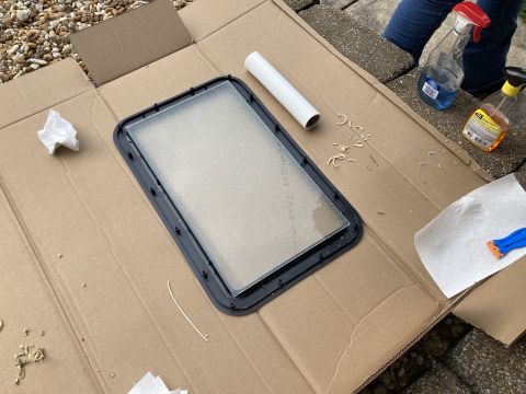 2015 Ford F-550 - A car door window assembly is laid out on cardboard with cleaning supplies nearby.