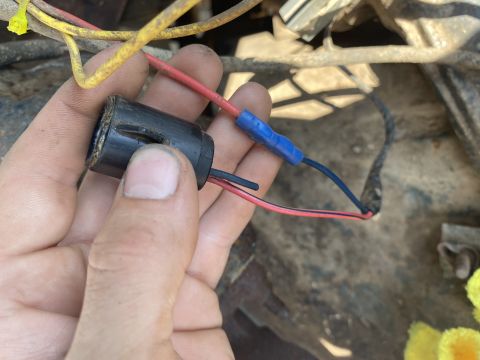 1976 Ford Bronco - Close-up of a hand holding a wiring connector with attached wires.