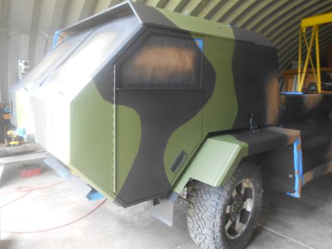 1992 Ford Bronco - This vehicle's cabin features a unique angular design and is painted in a green and black camouflage pattern.