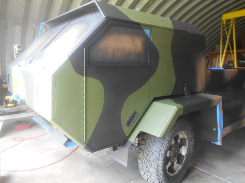 Camouflaged vehicle cabin with angular design and tinted windows