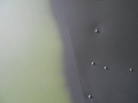 1992 Ford Bronco - A close-up view of a riveted metal panel, possibly from a vehicle's interior or exterior bodywork.