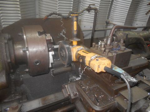 1992 Ford Bronco - Angle grinder attached to a metalworking lathe, cutting metal with sparks flying.