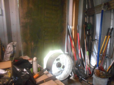 1992 Ford Bronco - A cluttered storage shed contains various tools, a fan, and other items.