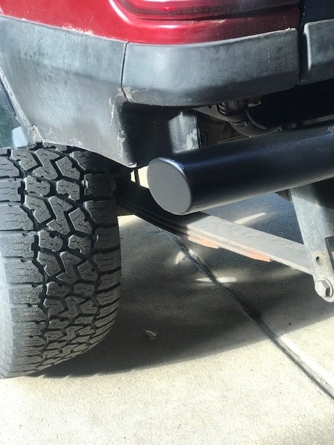 2000 Ford Explorer - Close-up view of the rear bumper and tire, showing an aftermarket exhaust pipe and leaf spring suspension.