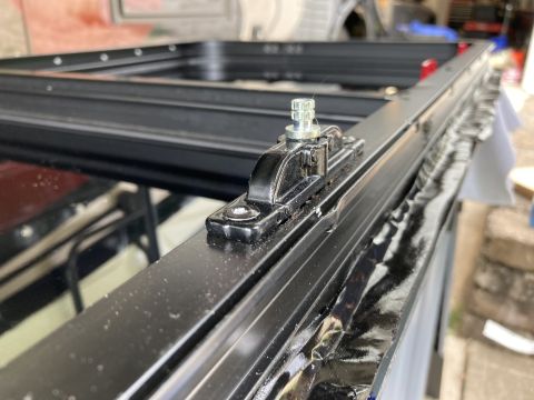 2015 Ford F-550 - A close-up view of a window frame assembly with a latch mechanism, possibly for a vehicle or RV.