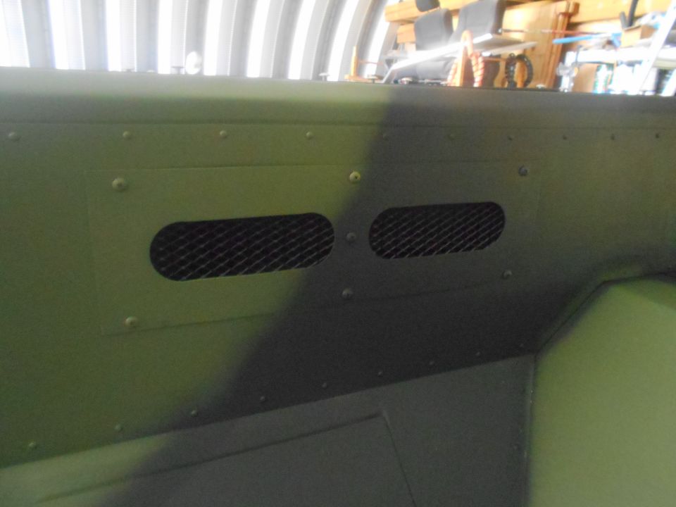 Green interior panel with two oval mesh vents and visible rivets