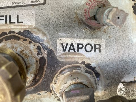 2015 Ford F-550 - Close-up of propane tank connections, indicating fill and vapor ports with visible signs of age and use.