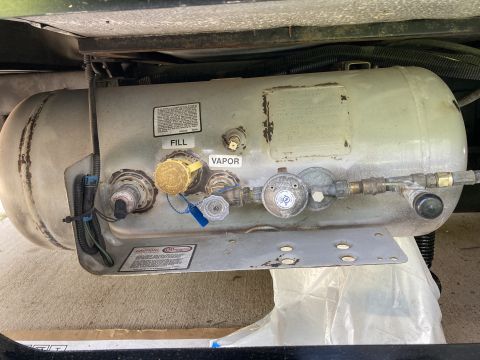 2015 Ford F-550 - Close-up view of a vehicle's propane tank system, showing various connections and a regulator.