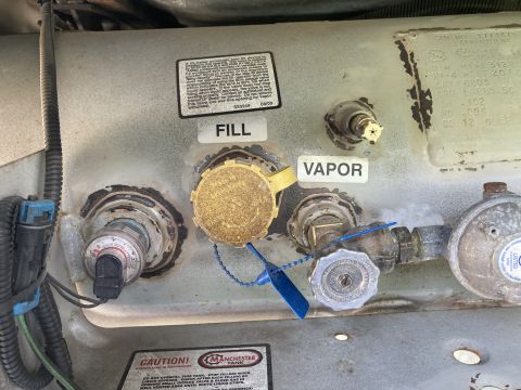 2015 Ford F-550 - Close-up of a propane tank's fill and vapor connections, showing various valves and labels.
