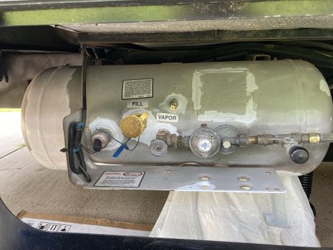 2015 Ford F-550 - A propane tank assembly is mounted beneath a vehicle, showing various connection points and safety warnings.