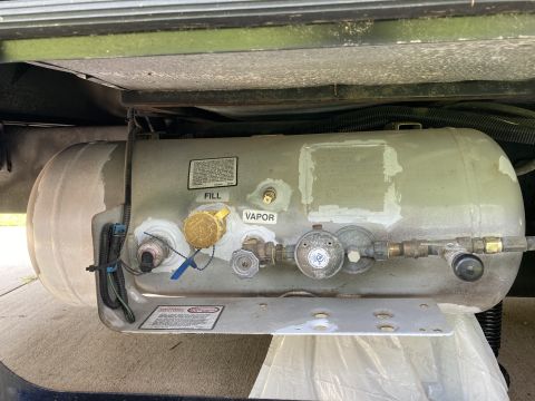 2015 Ford F-550 - A close-up view of a propane tank, showing its fill and vapor connections, as well as various valves and regulators.