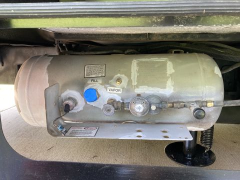2015 Ford F-550 - Close-up of a vehicle's propane tank assembly, showing various connections and a regulator.