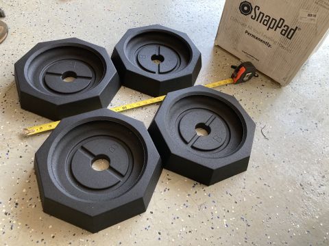 2015 Ford F-550 - Four black SnapPad leveling pads are shown with their packaging and a measuring tape, suggesting they are a product for RV or vehicle level…