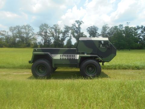 1992 Ford Bronco - This unique, camouflaged truck features a distinctive angular cab and large off-road tires, set against a backdrop of trees and a cloudy sk…