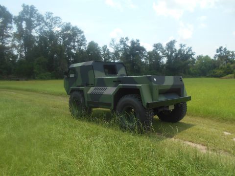 1992 Ford Bronco - This camouflaged truck is seen from a three-quarter front angle in a grassy field.