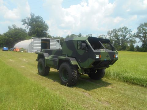 1992 Ford Bronco - This camouflaged truck features a unique design with a flatbed and tires, seen here in a grassy field.