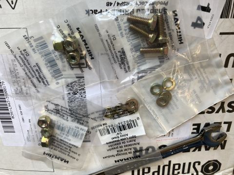 2015 Ford F-550 - Various hardware components, including nuts, bolts, and washers, are laid out with a wrench.