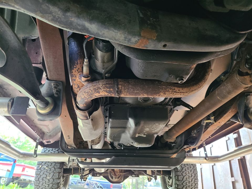 There are no substantial leaks, but the transmission pan & mount are grimy, and the rear diff appears to be seeping some oil around the left tube joint. Ford recommends flushing the underbody at least twice per year, and although this truck has less rust, mud, & grime than most, it doesn't appear to have been washed underneath recently.
IF THE IMAGE IS TOO SMALL, click it.