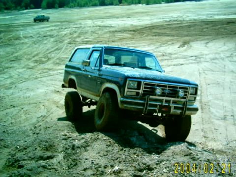 1985 Ford Bronco - Ford Bronco navigating a challenging terrain in a clay pit, with another vehicle in the distance.
