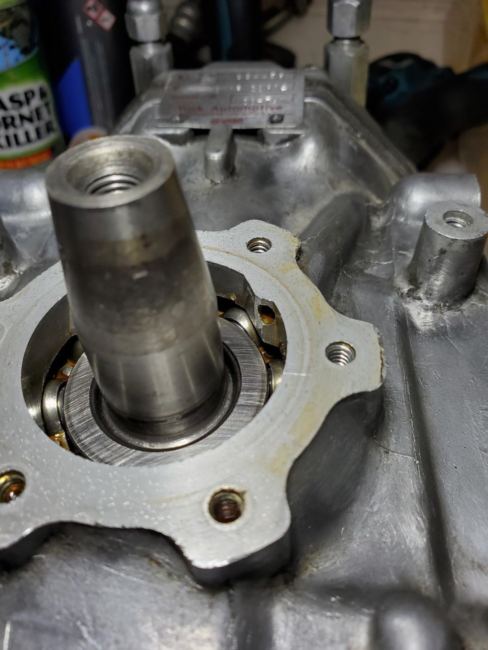 Metal component with bearing and threaded shaft, showing wear