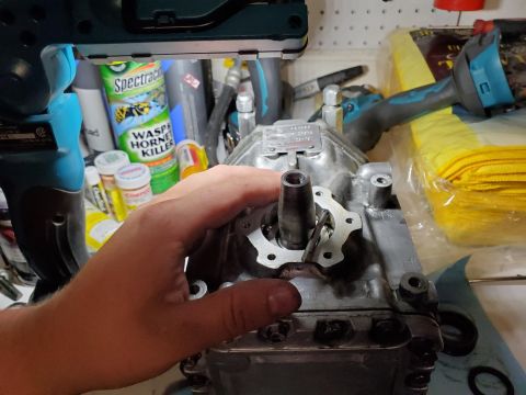 1996 Ford Bronco - Close-up of an air compressor component being held, with various workshop items in the background.