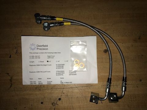 2000 Ford Explorer - Brake lines and hardware for a 2000 Ford Explorer are laid out on a wooden surface.