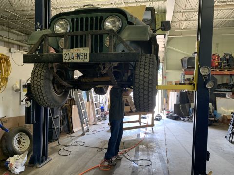 1979 Jeep CJ5 - Green 1979 Jeep CJ5 undergoing service on a two-post car lift in a workshop.