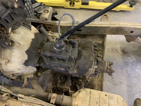 1979 Jeep CJ5 - The engine and transmission of a vehicle are shown, heavily soiled with oil and dirt.