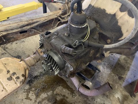 1979 Jeep CJ5 - The photo shows a greasy transmission and part of an exhaust pipe, likely in a repair shop.