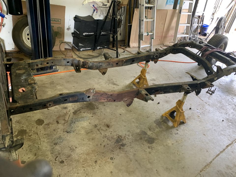 Vehicle frame on jack stands, showing rust and wear