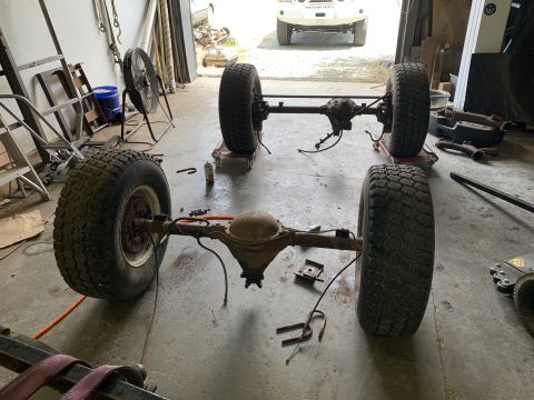 1979 Jeep CJ5 - Disassembled Jeep CJ5 axles and wheels are laid out on the garage floor.