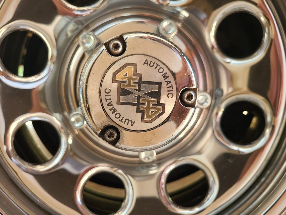 Chrome wheel hub with '4x4 AUTOMATIC' text and emblem