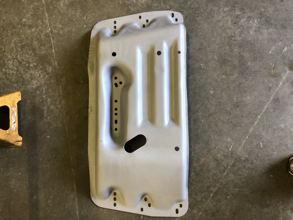 Metal skid plate with numerous mounting holes and an oval cutout