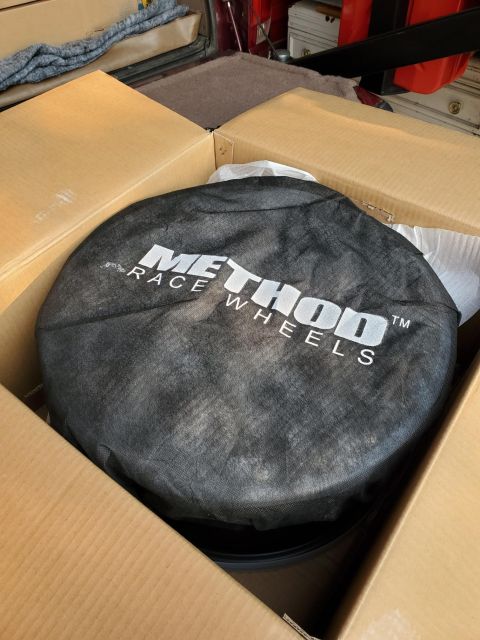 1996 Ford Bronco - A tire cover with 'Method Race Wheels' branding is shown inside a cardboard box.
