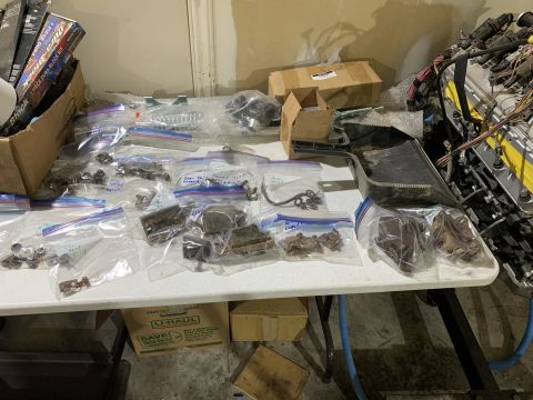 1979 Jeep CJ5 - Numerous small parts, likely for a Jeep CJ5, are organized in plastic bags on a folding table.