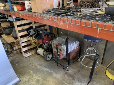 1979 Jeep CJ5 - An engine block is stored on a stand in a workshop, alongside various tools and equipment.