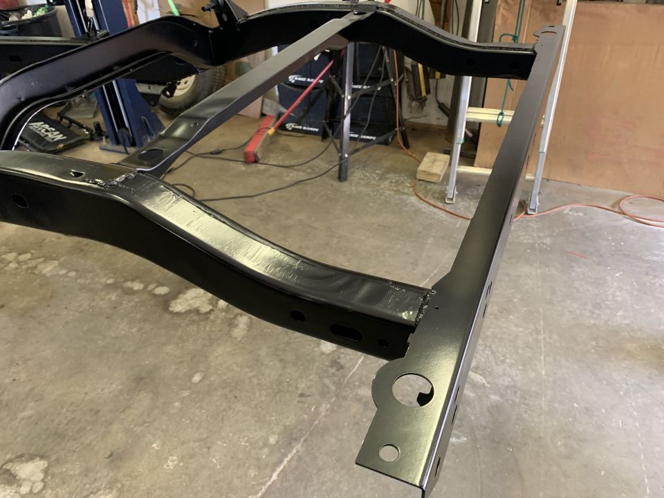 Black painted vehicle frame on a concrete floor