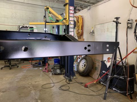 1979 Jeep CJ5 - A vehicle frame is being worked on in a garage, with tools and equipment around.