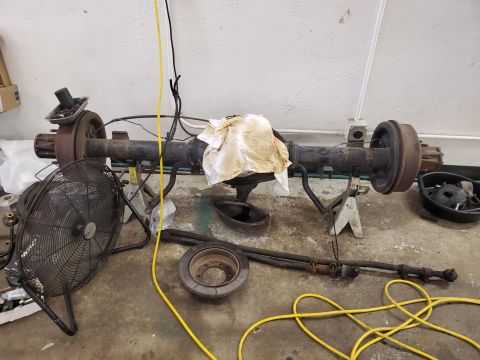 1996 Ford Bronco - Rear axle assembly, likely from a 1996 Ford Bronco, sits on jack stands in a workshop.