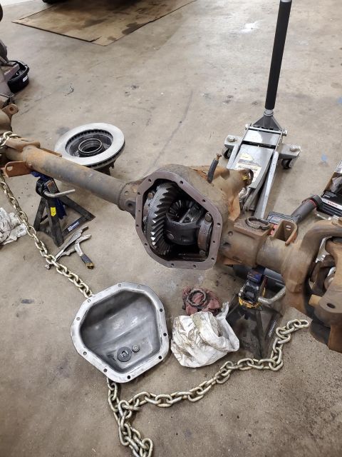 1996 Ford Bronco - A vehicle's front axle assembly is disassembled in a garage, with the differential exposed.